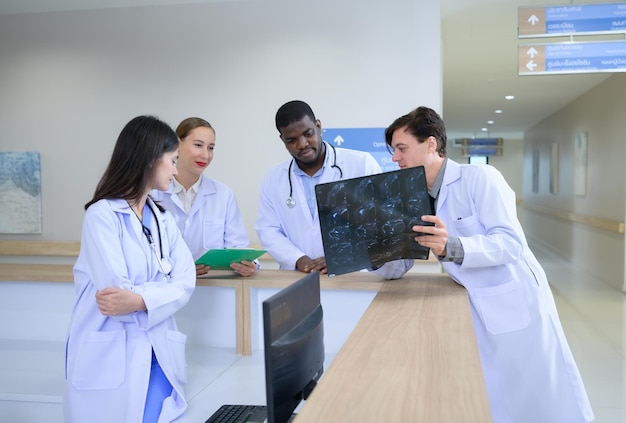 Medical teacher and interns analyzing the xray results of the patients brain before major surgery