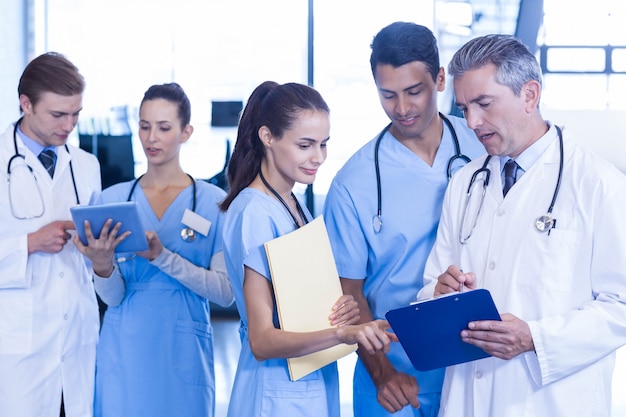 Medical team discussing paperwork on clipboard at the hospital