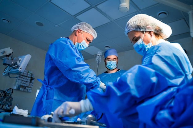 Medical team helping patient Surgeon with his team performing surgery on a patient operating theatre room