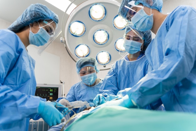 Медицинская бригада, выполняющая хирургическую операцию в операционной больнице Медицинская бригада, выполняющая критическую операцию