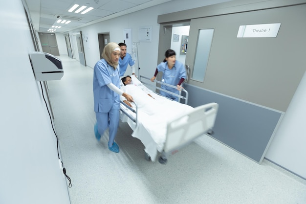 Medical team pushing emergency stretcher bed in corridor
