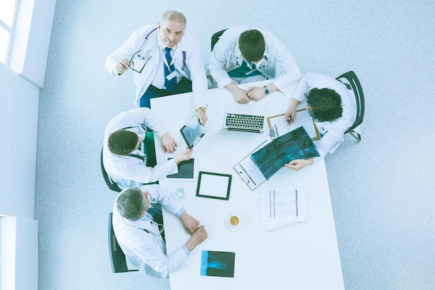 Medical team sitting and discussing at table top view