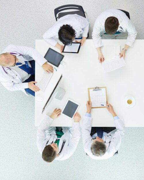 Medical team sitting and discussing at table top view