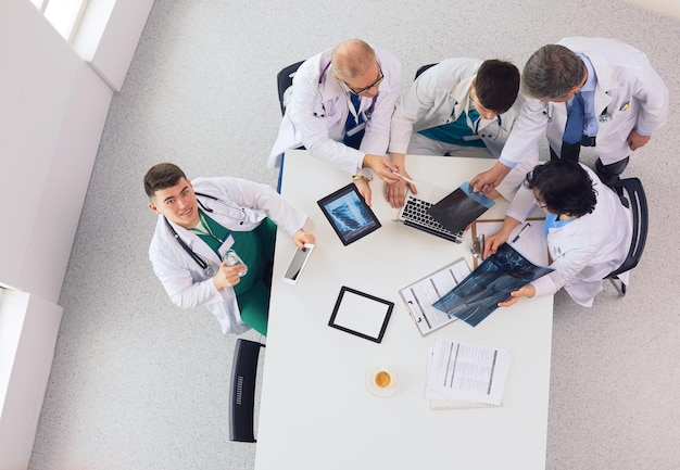 Medical team sitting and discussing at table top view