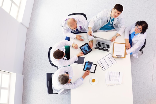 Medical team sitting and discussing at table top view