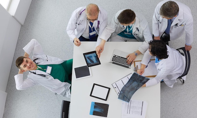 Medical team sitting and discussing at table top view