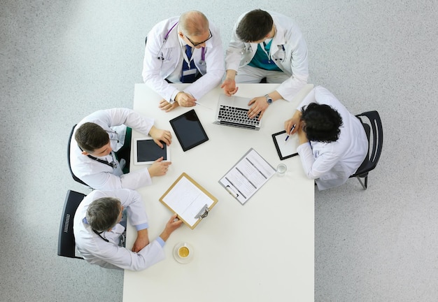 Medical team sitting and discussing at table top view