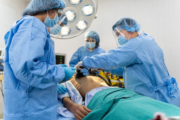 Medical team in Surgical gown help patient to making CPR Cardio Pulmonary Resuscitation in the operation room in hospital