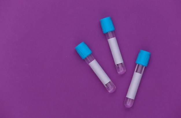 Photo medical test tubes on purple background. top view