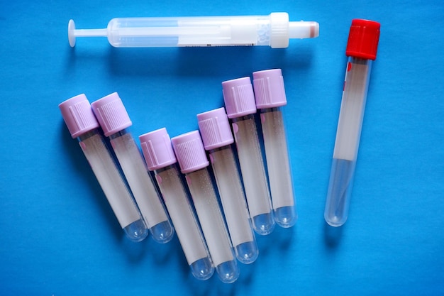 medical test tubes and syringe on blue background