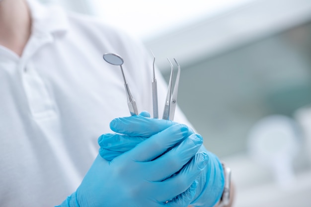 Medical tools. Close up pictire of doctors hands with dental medical tools