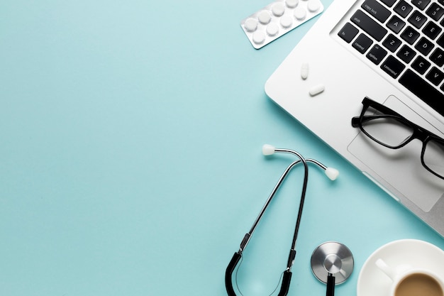 Photo medical tools with notepad; laptop and cup of coffee over desk