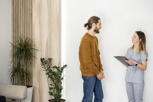 Medical worker communicates with male patient at the reception of the clinic