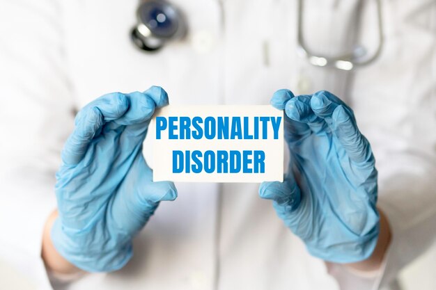 A medical worker in gloves holds a card with the words PERSONALITY DISORDER Medical concept