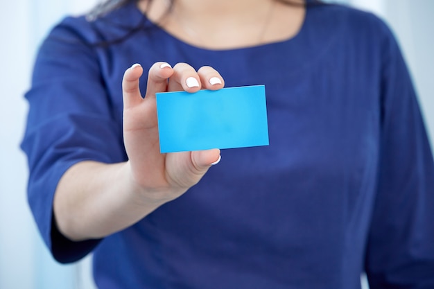 A medical worker holds a business card close-up with a place to copy the text