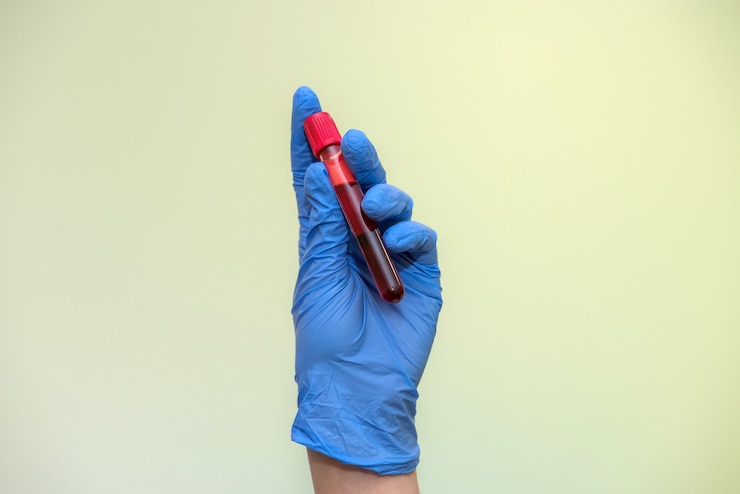 Photo medical worker in protective costume holding red test tubes in hands in laboratory