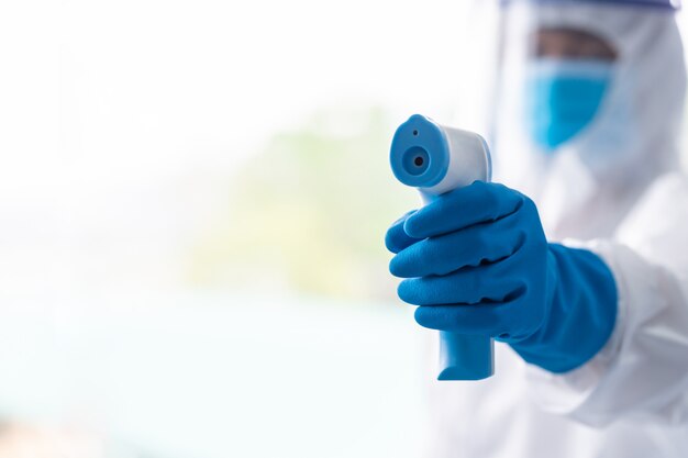 Medical worker scanning with infrared thermometer