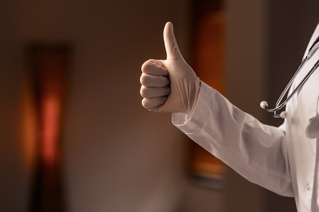 Medical worker shows gesture ok. White latex gloves,