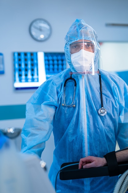 Medical worker wearing PPE in operation unit. Fighting against spread of coronavirus. mask, protective glasses and protective suit.