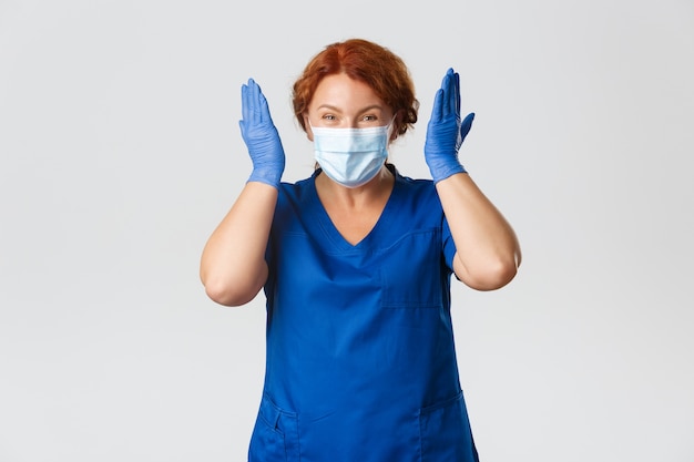 Foto operatori sanitari, pandemia covid-19, concetto di coronavirus. medico femminile sorridente eccitato e felice, infermiera o medico di mezza età in maschera e guanti che si rallegrano per le grandi notizie.