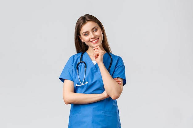 Operatori sanitari, assistenza sanitaria, covid-19 e concetto di vaccinazione. bella infermiera sorridente ottimista, dottore in camice blu, clinica di lavoro, guardando con una telecamera con sguardo entusiasta, ascoltando il collega