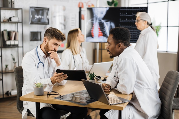 Medical workers with gadgets having meeting at clinic