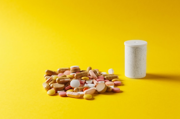 Medicatie witte kleurrijke ronde tabletten abstract gerangschikt op gele kleur achtergrond