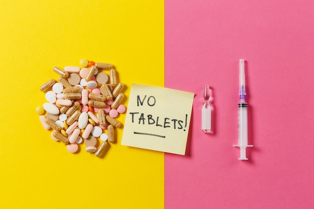 Medication colorful pills arranged abstract on yellow pink background