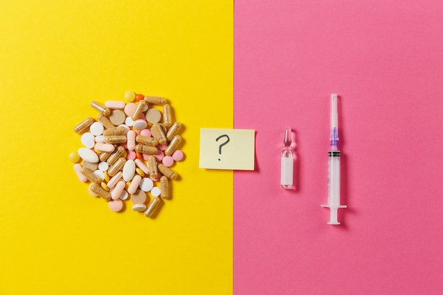 Medication colorful tablets, pills arranged abstract on yellow pink background