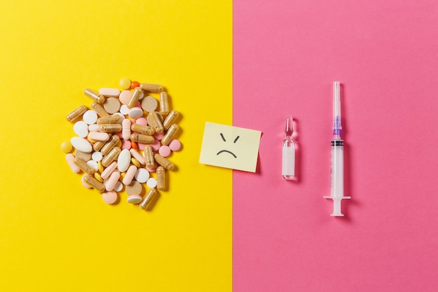 Photo medication colorful tablets, pills arranged abstract on yellow pink background