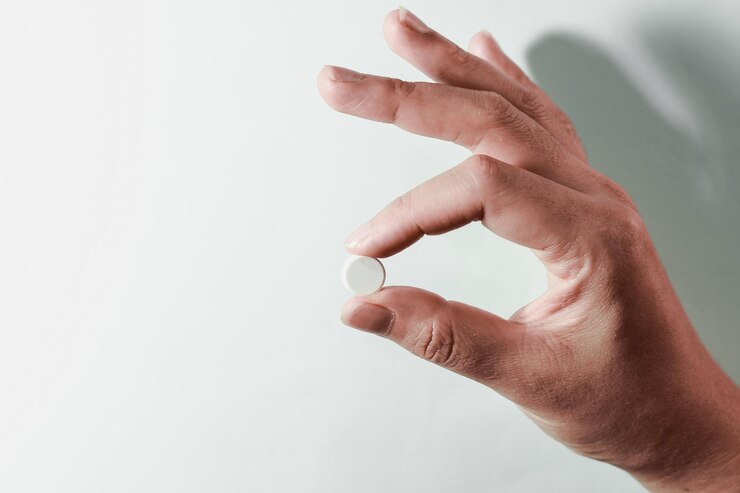 Photo 薬は手に 白い種子の薬は指に 青い背景に