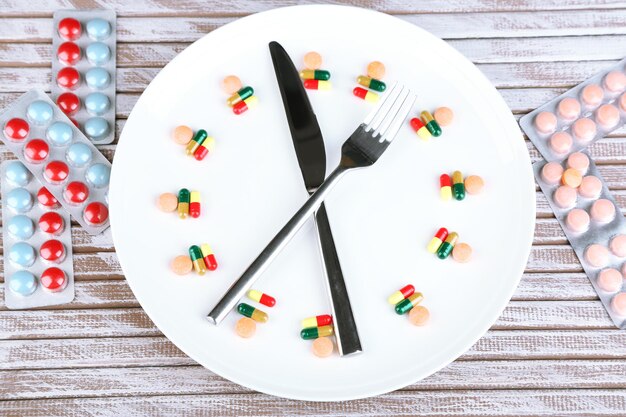 Medication schedule and meals Conceptual photo On wooden background