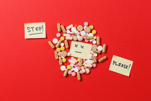 Medication white colorful round tablets arranged abstract on red color background