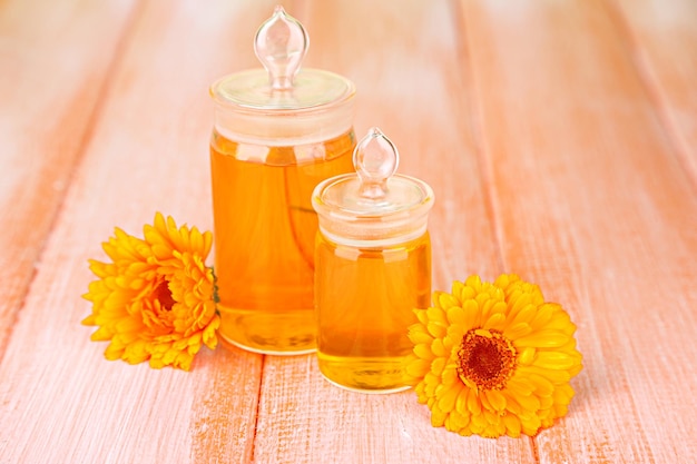 Medicijnflessen en calendula bloemen op houten achtergrond