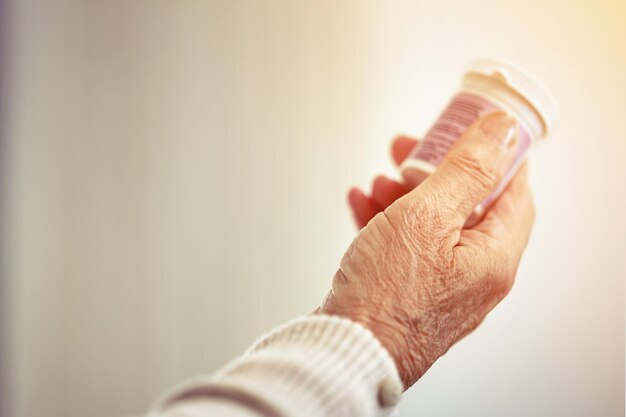 Medicijnvrouw en handen met een fles pillen voor herstel, gezondheid en welzijn Gezondheidszorgmedicatie en close-up van een senior vrouwelijke persoon met voorgeschreven tabletten, supplementen of vitamines