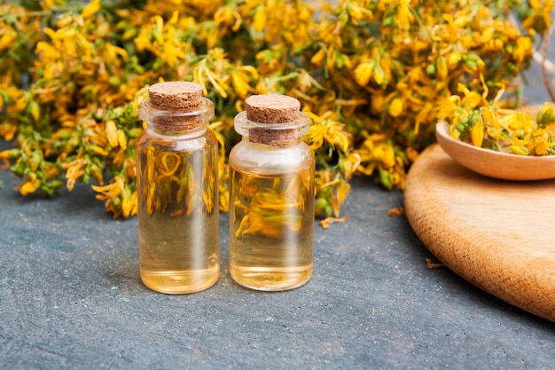 Medicinal herb St. John's wort and tincture in bottles. Herbal treatment and natural cosmetics concept.