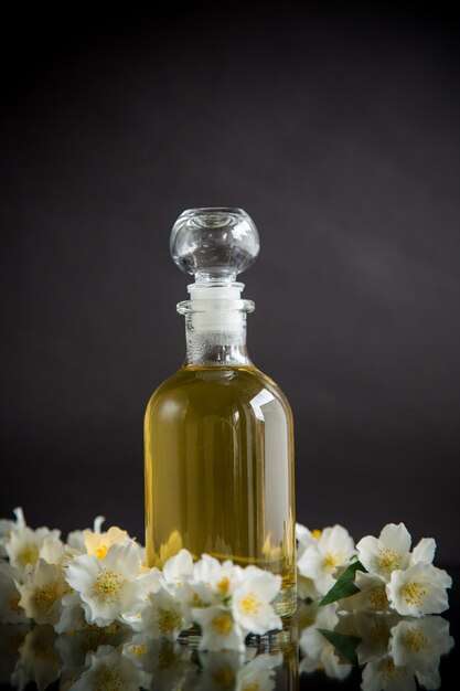 Medicinal herbal tincture with jasmine in a glass bottle on a black background