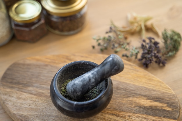 Medicinal herbs, mortar of healing herbs, sachet and bottle of healthy drugs on wooden table. Herbal medicine. Top view, flat lay.