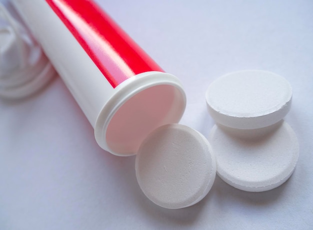 Medicinal large round pills are scattered from a bottle container closeup