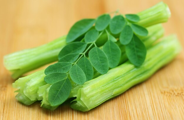 Moringa oleifera medicinale con foglie su superficie in legno