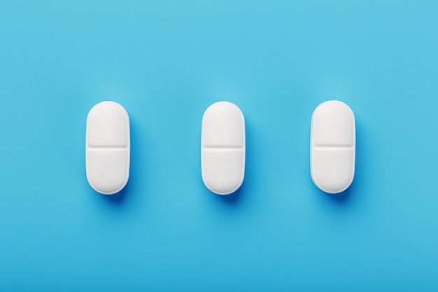 Photo medicinal tablets in a row on blue