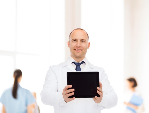 medicine, advertisement and teamwork concept - smiling male doctor showing tablet pc computer screen over group of medics