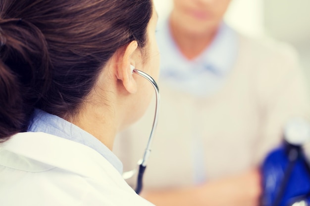 Photo medicine, age, health care and people concept - close up of doctor with tonometer checking senior woman blood pressure level at hospital