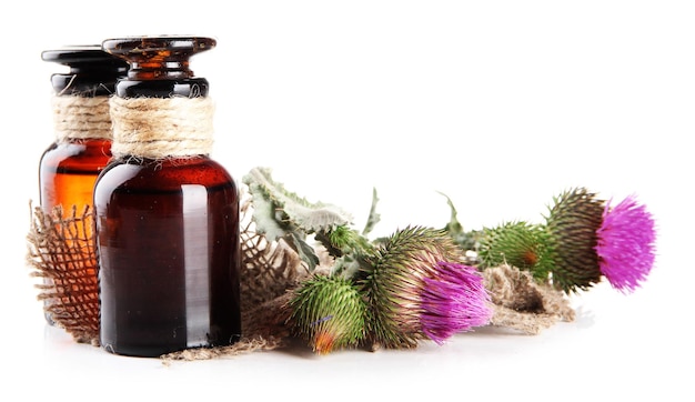 Medicine bottles with thistle flowers isolated on white