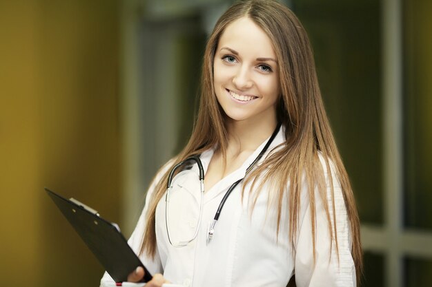 笑顔、自信を持って女性医師、白衣と聴診器を持つ医療専門家のMedicine.Closeupの肖像画。