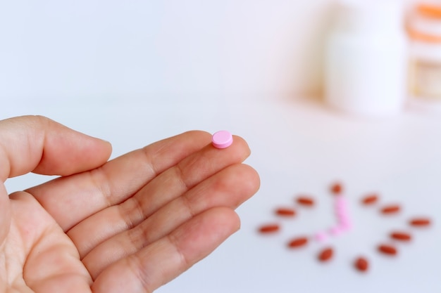 Medicine concept; take a medicine on time everyday, The pink pill is on the finger.