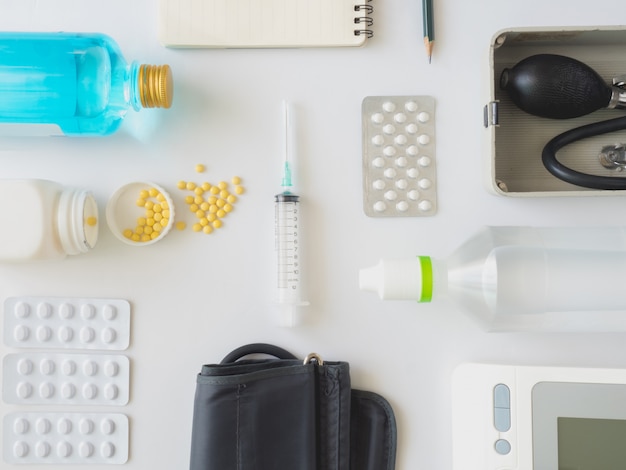 Medicine concept with drugs in a bottle, saline solution, pills, Tablet, ethyl alcohol, injection needle, Digital Blood Pressure Monitor, Manual Blood Pressure Measurement on white background.