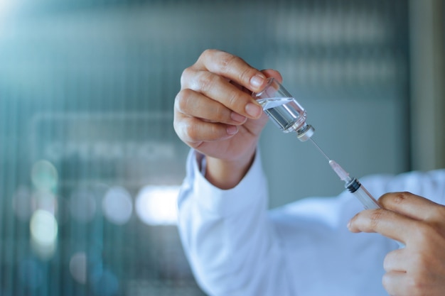 Medicine doctor and vaccine dose flu shot drug syringe in laboratory