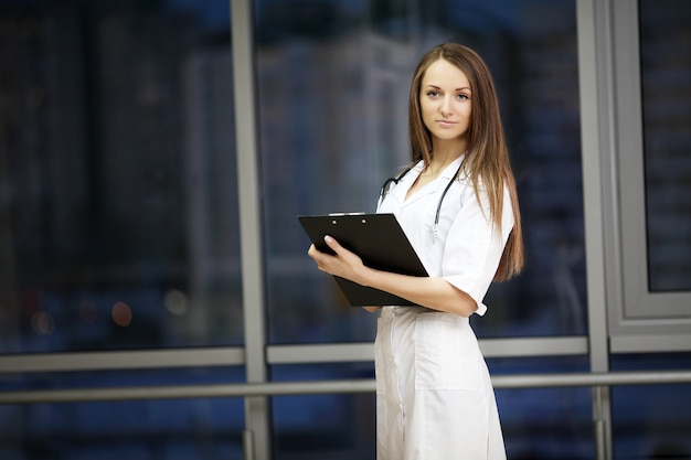 Medicine.  Female doctor smiles. Practice in the hospital. Family doctor. A young woman is beautiful. Give notes