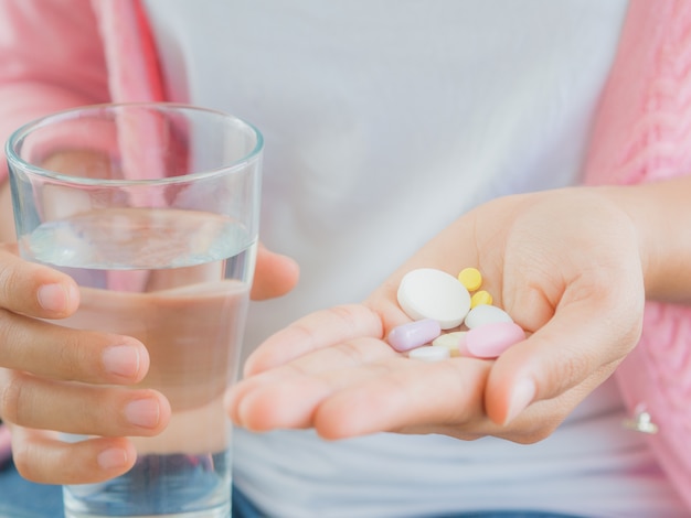 Medicine, health care concept - close up of woman taking in pill.